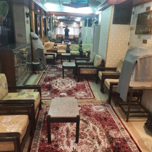 a room filled with lots of tables and couches at San mina Hotel in Luxor