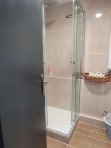 y baño con ducha y puerta de cristal. en Appartement privé à 15mn de Paris et proche Enghien les bains en Groslay