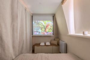 1 dormitorio con TV en la pared en Studio duplex standing centre - Lille aux Bleuets, en Lille