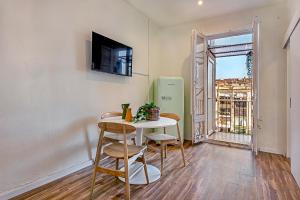 una pequeña mesa y sillas en una habitación con ventana en Clandestino Suites, en Barcelona