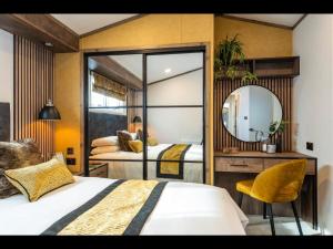 a bedroom with two beds and a mirror at Sure Studio by Best Western Brackenborough Lakes & Resort in Louth +140 photos