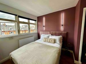 - une chambre avec un grand lit et 2 oreillers dans l'établissement Cozy Studio near Regent’s Park N9, à Londres