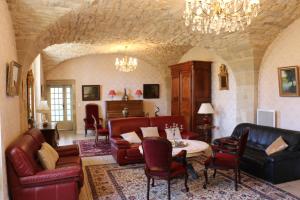 a living room with leather furniture and a chandelier at CHATEAU DE SAINTE ORSE in Sainte-Orse