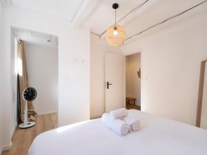- une chambre avec un lit blanc et des serviettes dans l'établissement Le Keller - Nancy-Centre - Ideal pros, à Nancy
