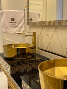 un bagno con lavandino d'oro su un bancone di مساكن ميرنا a Taif