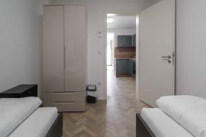 a white room with two beds and a kitchen at bonquartier / SU-City / Terrace / ICE / Airport in Siegburg
