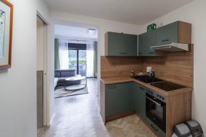 a kitchen with green cabinets and a stove top oven at bonquartier / SU-City / Terrace / ICE / Airport in Siegburg