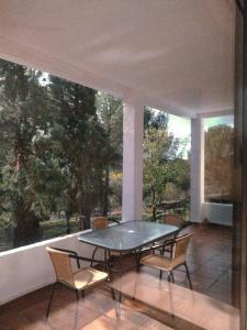 a patio with a table and chairs on a balcony at Bonita casa blanca en el bosque. in Córdoba