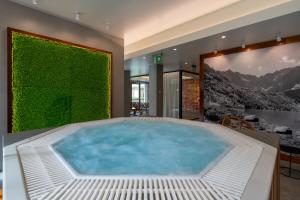 a hot tub in a room with a green wall at RentPlanet - Apartamenty Zakopiańskie in Zakopane
