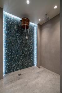y baño con ducha y pared de azulejos azules. en RentPlanet - Apartamenty Zakopiańskie, en Zakopane