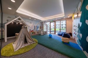 RentPlanet - Apartamenty Zakopiańskie في زاكوباني: غرفة للأطفال مع منطقة لعب مع خيمة