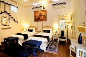 een slaapkamer met 2 bedden en een open haard bij The Royal Hermitage - Best Luxury Boutique Hotel Jaipur in Jaipur