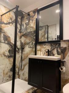 a bathroom with a shower and a sink and a mirror at Apartament Zielony by Homeprime in Bukowina Tatrzańska