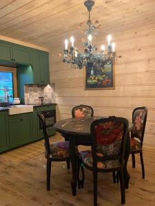 een keuken met een tafel en stoelen en een kroonluchter bij Apartament Zielony by Homeprime in Bukowina Tatrzańska