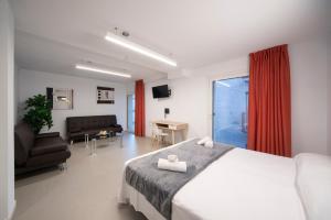 1 dormitorio con 1 cama y sala de estar en Epsilon Alcañiz Hotel, en Alcañiz