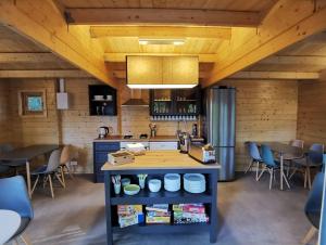 梅斯蘭德的住宿－La Parenthèse Meslandaise，一间带小岛的厨房,位于带木制天花板的房间内