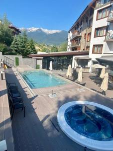 a swimming pool on a deck next to a building at Bansko St Ivan Rilski Luxury Apartment 4 stars Free SPA & Mineral water in Bansko