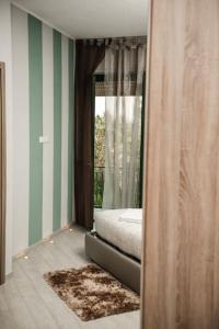 um quarto com uma cama e uma grande janela em Luxury experience in Alba: Unesco hills' hearth em Guarene