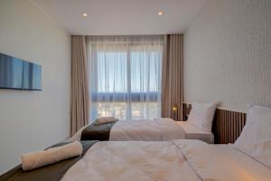 Cette chambre comprend 2 lits et une fenêtre. dans l'établissement Mayfair by Premier Suites MT, à Is-Swieqi