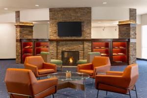 a waiting room with chairs and a fireplace at Courtyard by Marriott Madison West / Middleton in Middleton