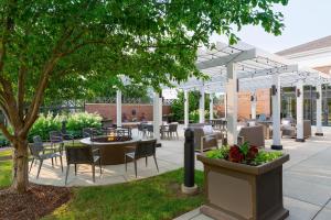 un patio con mesas, sillas y un árbol en Courtyard by Marriott Madison West / Middleton, en Middleton