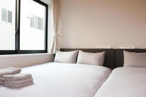 dwa łóżka w pokoju z oknem w obiekcie Seirai Asakusa Vacation Rental - 3 minutes from station w Tokio