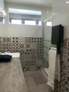 a bathroom with a shower and a television on the wall at Cocoon Bugiste : travail, sport ou détente in Hauteville-Lompnes