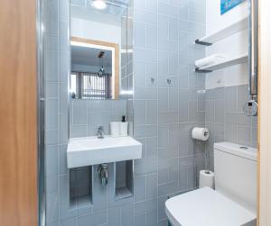 un baño con lavabo e inodoro en New Stylish Studio Flat near Woolwich tube, en Woolwich