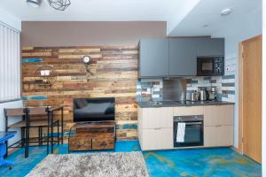cocina con pared de madera y mesa en New Stylish Studio Flat near Woolwich tube, en Woolwich 12 fotos más