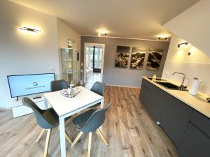 a kitchen and dining room with a white table and chairs at StadtHeimat29 in Münster