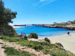 a person walking on a beach near the water at Right by the Sea • Les Embruns in Martigues