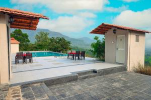 a patio with a table and chairs and a pool at Shinde's Tikona Valley Farm in Pune