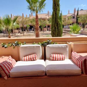 een witte bank met kussens op een patio bij Un Oasis en Hacienda del Álamo in Murcia
