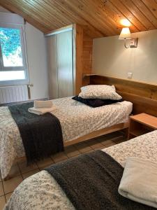 Un dormitorio con dos camas en una habitación con techos de madera. en Domaine des oiseaux, en Sapois 46 fotos más