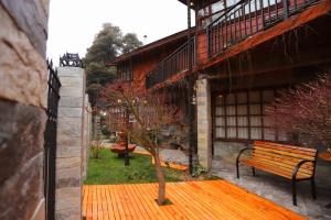 un banco sentado en un patio junto a un edificio en Hostal Collins House, en Temuco