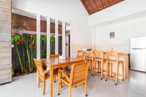 comedor con mesa de madera y sillas en Villa Joylen Seminyak Bali en Seminyak