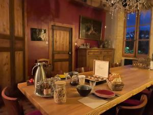 a wooden table with food and a kettle on it at Les Jardins des Soussilanges in Céron