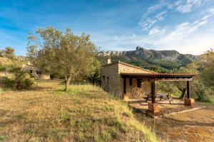 Cabaña de piedra con mesa de picnic en un campo en Casa Rural Ca Ferminet & Cabañas de montaña La Garriga en Benisili