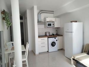 uma cozinha com um frigorífico e uma máquina de lavar roupa em Mirador de Sotavento apartment 103 em Costa Calma
