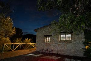 una casa de piedra con 2 ventanas por la noche en Casa Rural Ca Ferminet & Cabañas de montaña La Garriga en Benisili
