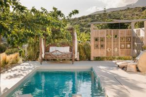 a pool in the backyard of a house with a swing at Spathes Luxury Private Pool Villa with Sea View in Kefalonia in Ratzaklíon
