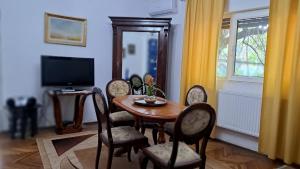 uma sala de jantar com uma mesa e cadeiras e uma televisão em Casa Dell'Edera em Bucareste