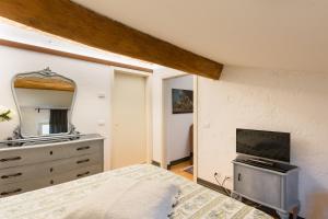 um quarto com uma cama e uma cómoda com um espelho em B&B Corte del Mincio em Monzambano