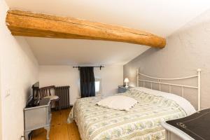 a bedroom with a bed with a wooden beam at B&B Corte del Mincio in Monzambano