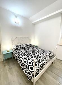 a bedroom with a black and white bed and two tables at Delizioso Appartamento in Via di Monte Verde in Rome