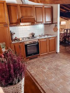 a kitchen with wooden cabinets and a vase of flowers at Nuvola - Villa Cenami - grande PISCINA con vista in Massarosa