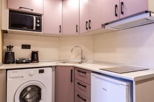 a kitchen with a washing machine and a microwave at Studio Flat 6 min to Yedikule Fortress in Istanbul