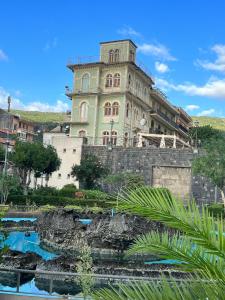a large building sitting on top of a stone wall at Casa vacanze al castello in Zafferana Etnea