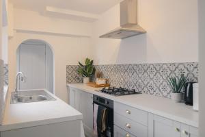 a white kitchen with a sink and a stove at Newly Refurbished House with Free Parking in Rugby