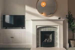 a living room with a fireplace with a mirror at Newly Refurbished House with Free Parking in Rugby